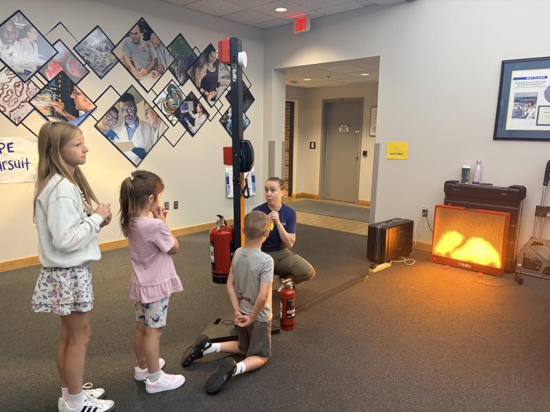 A volunteer explains the process of a 911 call and how to use a fire extinguisher. Image credit: Karolina Wilk