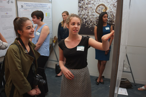 One of Rich’s photos from the 2016 Bethesda Student Poster Day. Student intern Rebecca Matthews (center) explains her research to intern Nathalie Walker (left). Walker was one of the many interns Rich mentored.