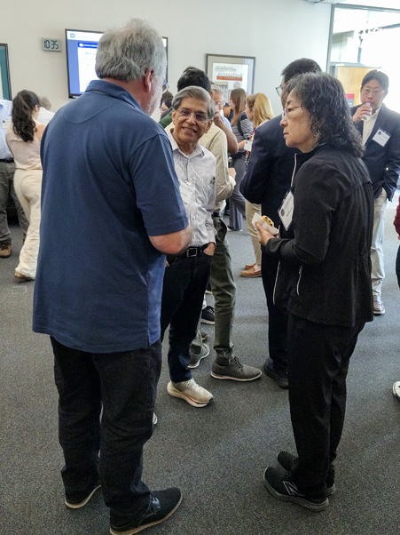 Senior investigators Wei-Shau Hu, Ph.D., (right) and Vinay Pathak, Ph.D., (center) converse with a colleague during a break. Hu is also an HIV DRP deputy director. (Photo by Samuel Lopez.)