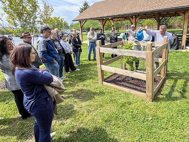 The Green Team Campus Improvement Committee’s Adam Leaman and Helene Highbarger water the Moon Tree to formalize the dedication. (Photo by Kylee Stenersen)