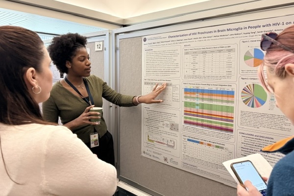 Alana Thomas (back, left) explains her research on her winning poster to Postbac Poster Day attendees. Image credit: Terry Jones