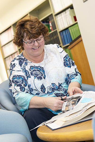 Pam Noble cutting newspaper clippings